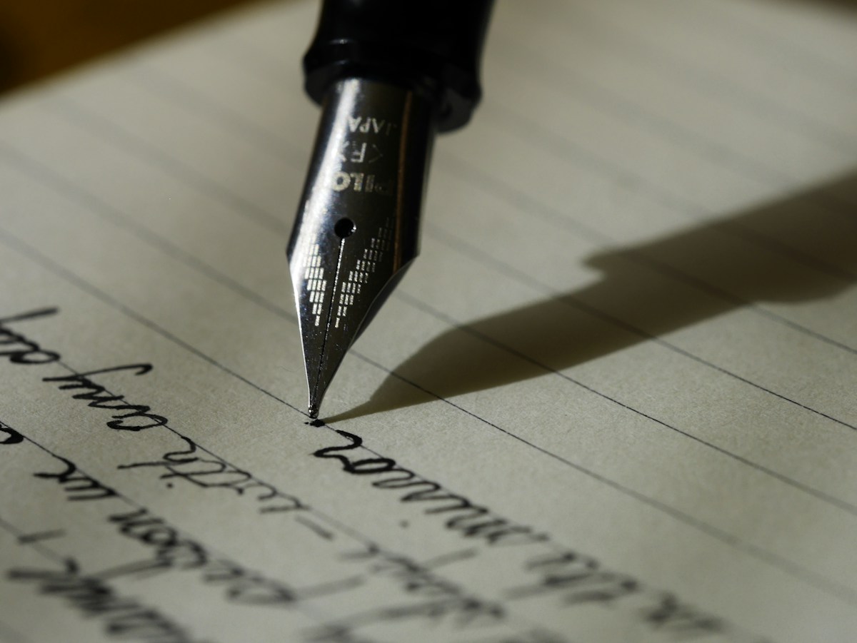 A writer developing clear, considered language in a notebook